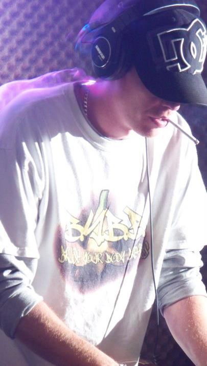 DJ Natural Nate® close up in Bruise Your Body shirt under purple light